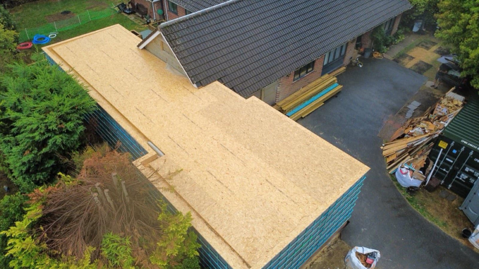 Aerial view of OSB roof decking on a timber frame house extension mid-build