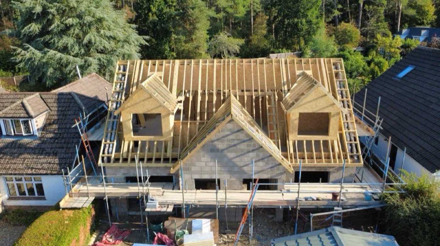 Aerial view of a new timber roof frame with twin dormers under construction