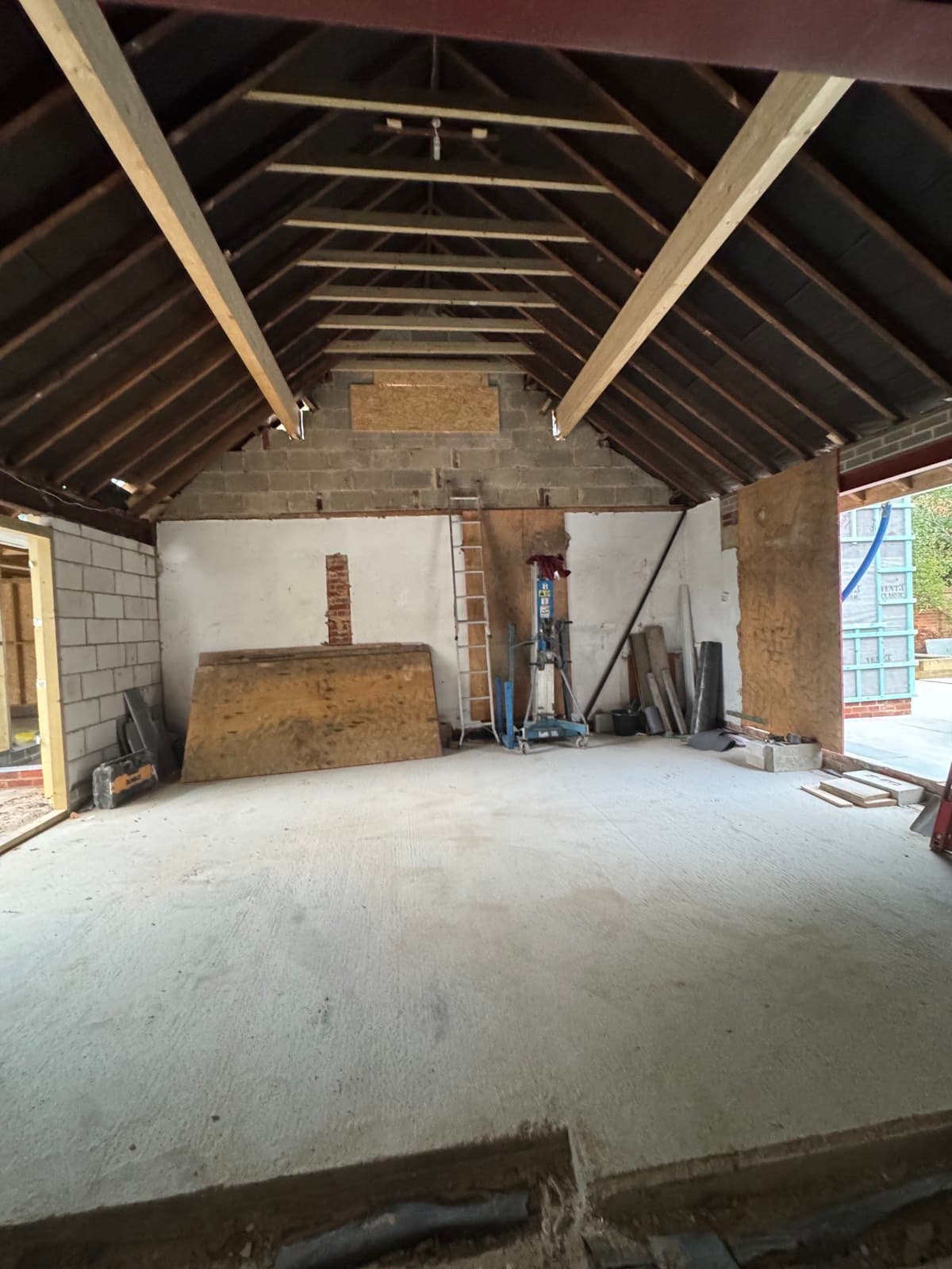 Exposed timber roof structure inside a single-storey extension under construction