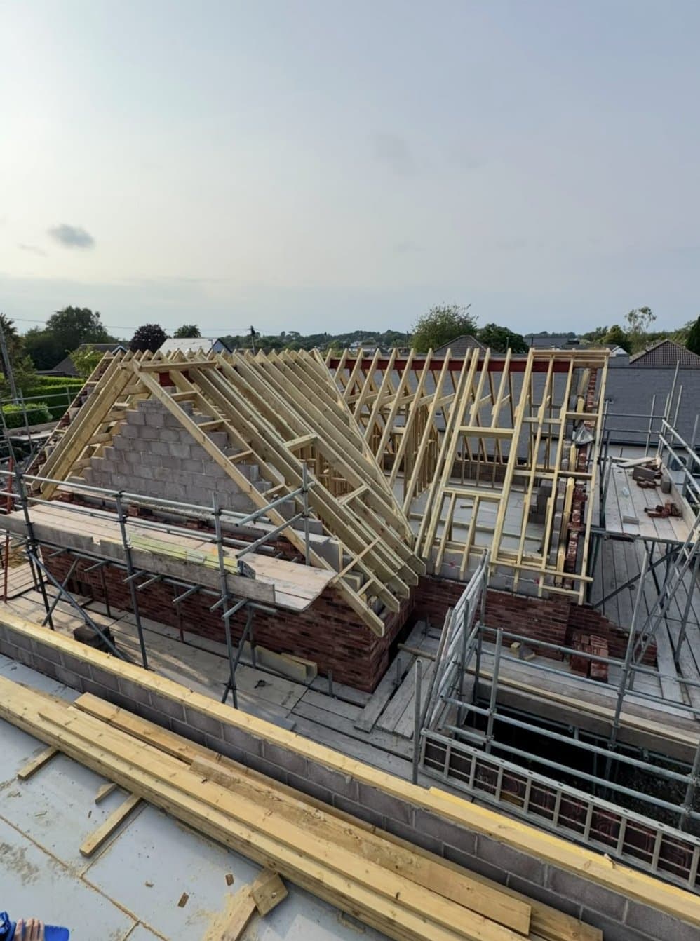 New timber roof trusses and dormer framing going up on a brick extension