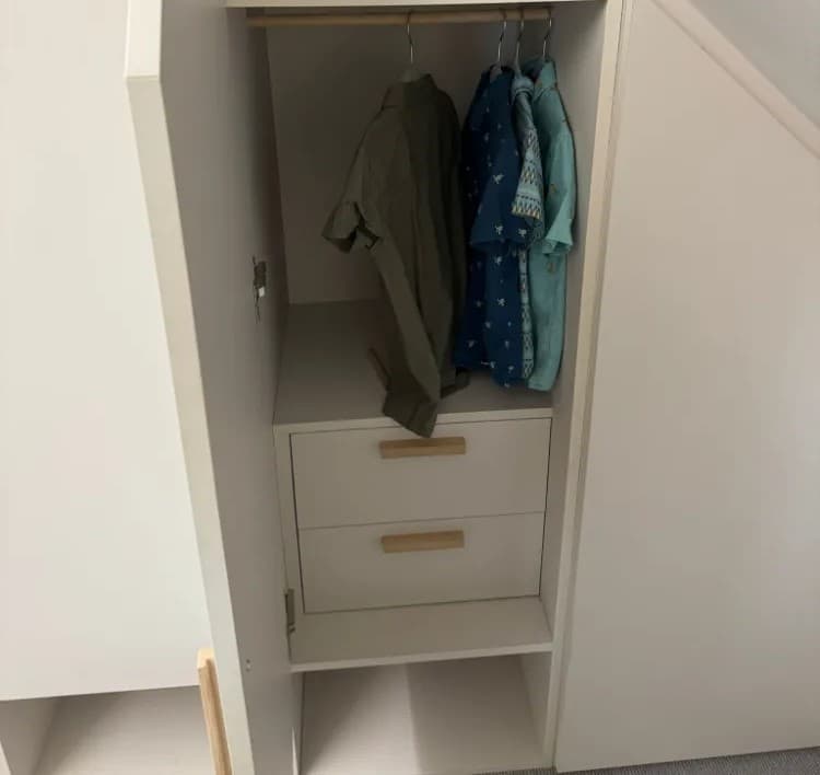 Fitted wardrobe with hanging rail and integrated drawers in an alcove nook