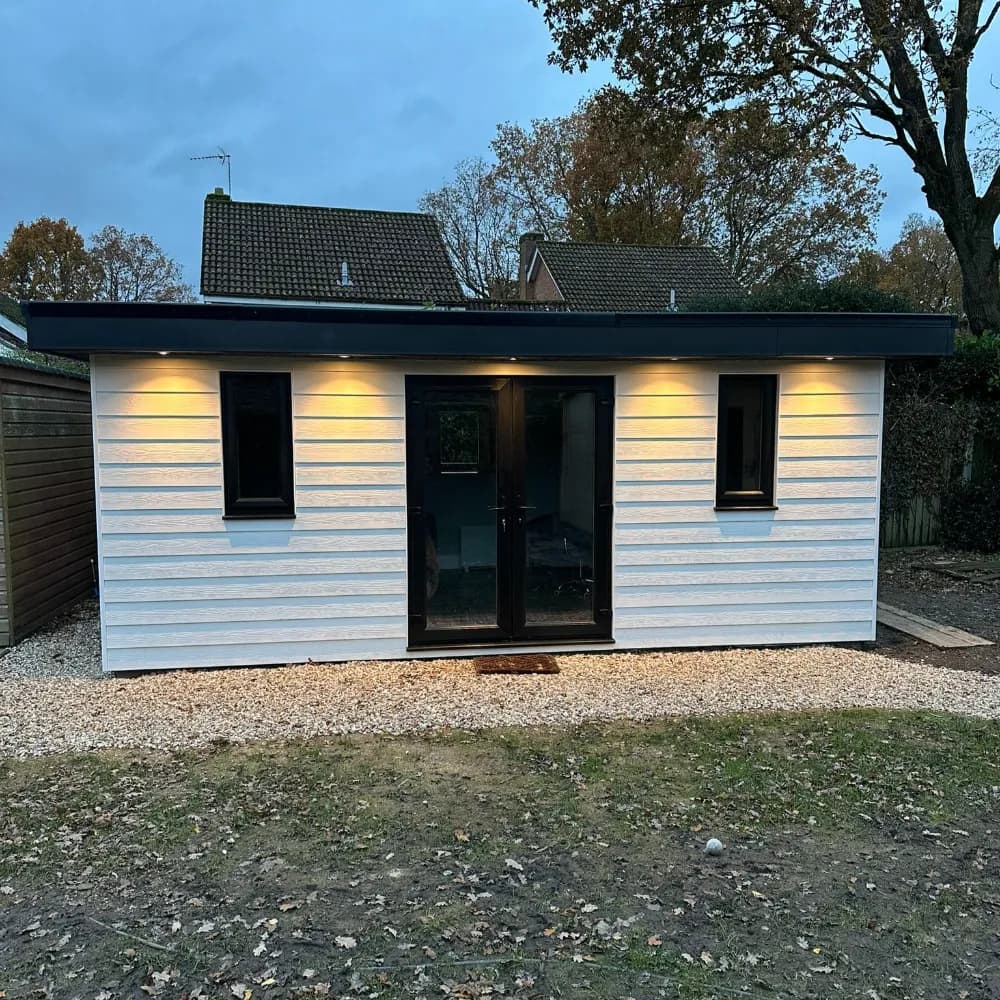 Finished white-clad garden office with flat black roof and black-framed double doors
