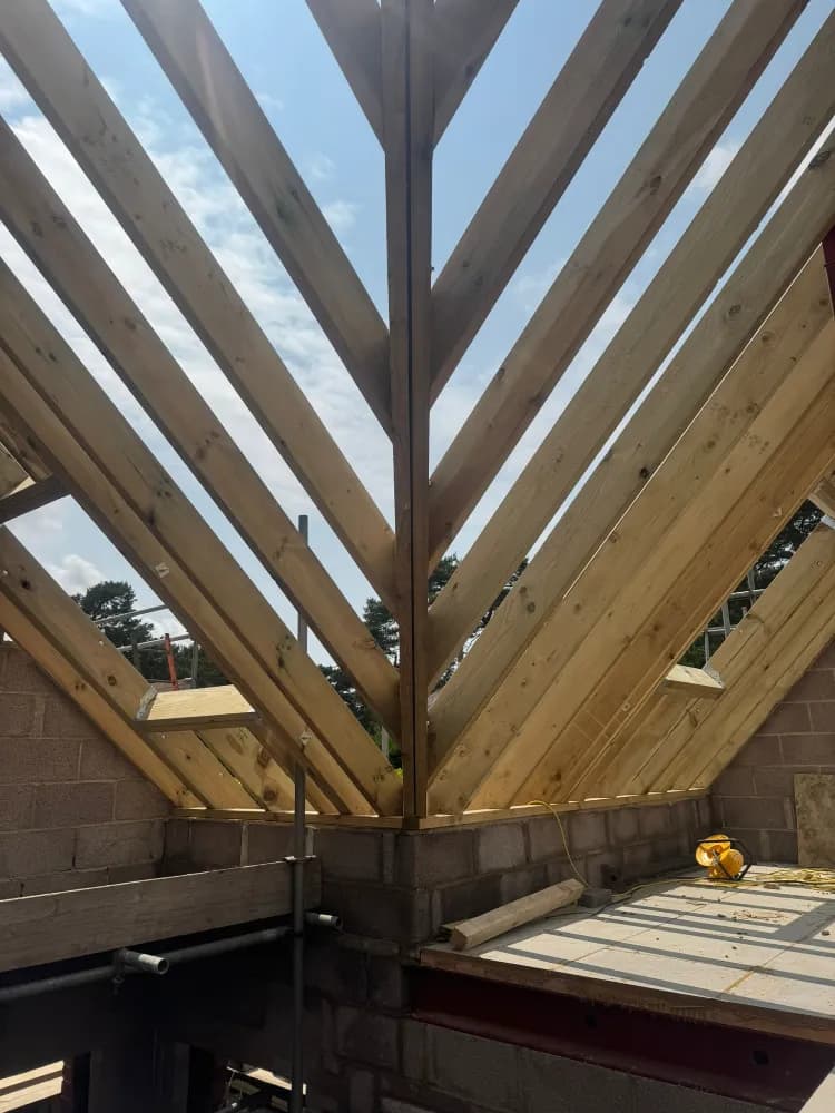 Timber hip roof rafters converging at the ridge on a new-build carpentry project