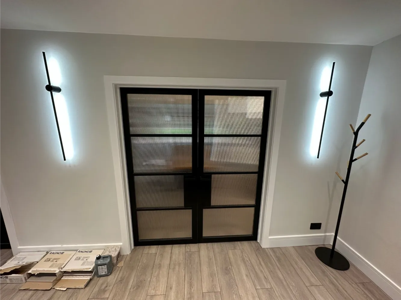 Black-framed double internal doors with reeded glass and white architrave in a hallway