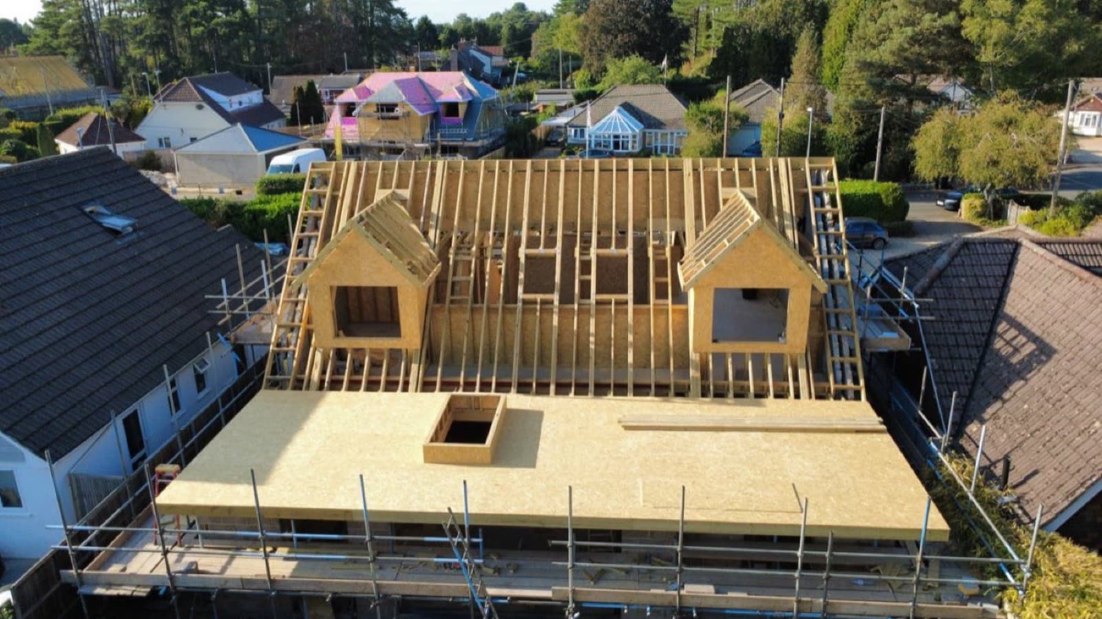 Aerial view of a timber roof frame with two dormer windows under construction