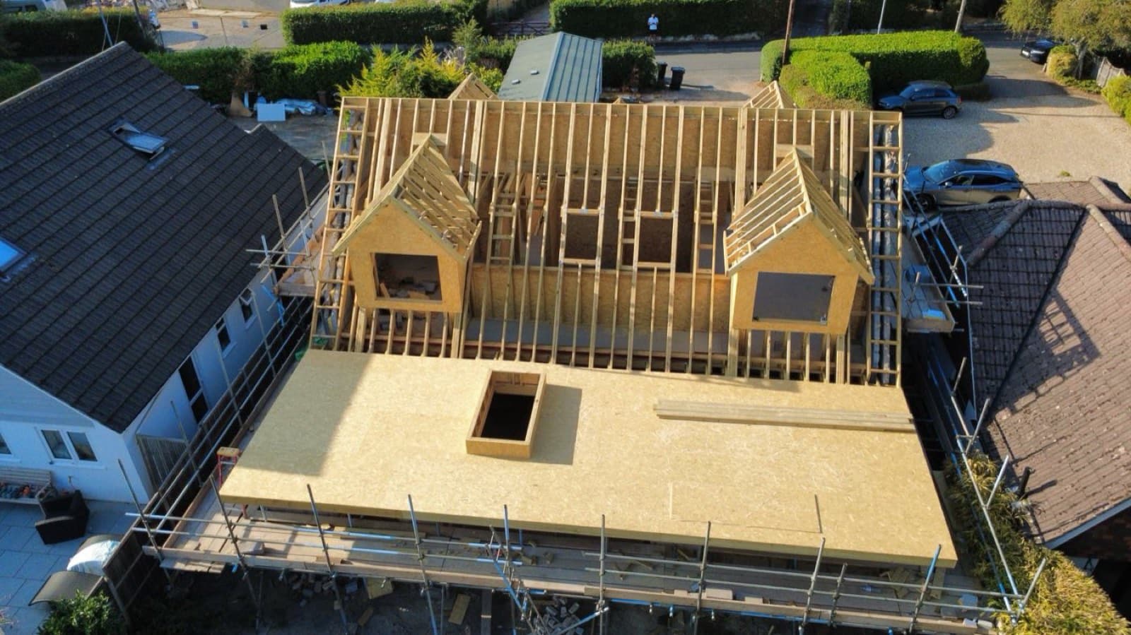 Aerial view of a timber-framed loft conversion roof with two dormers under construction