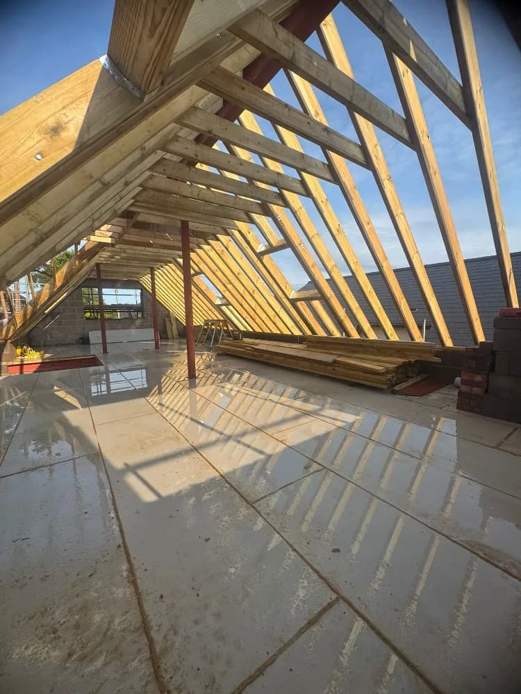 Exposed timber roof rafters and steel beams mid-build on a loft conversion
