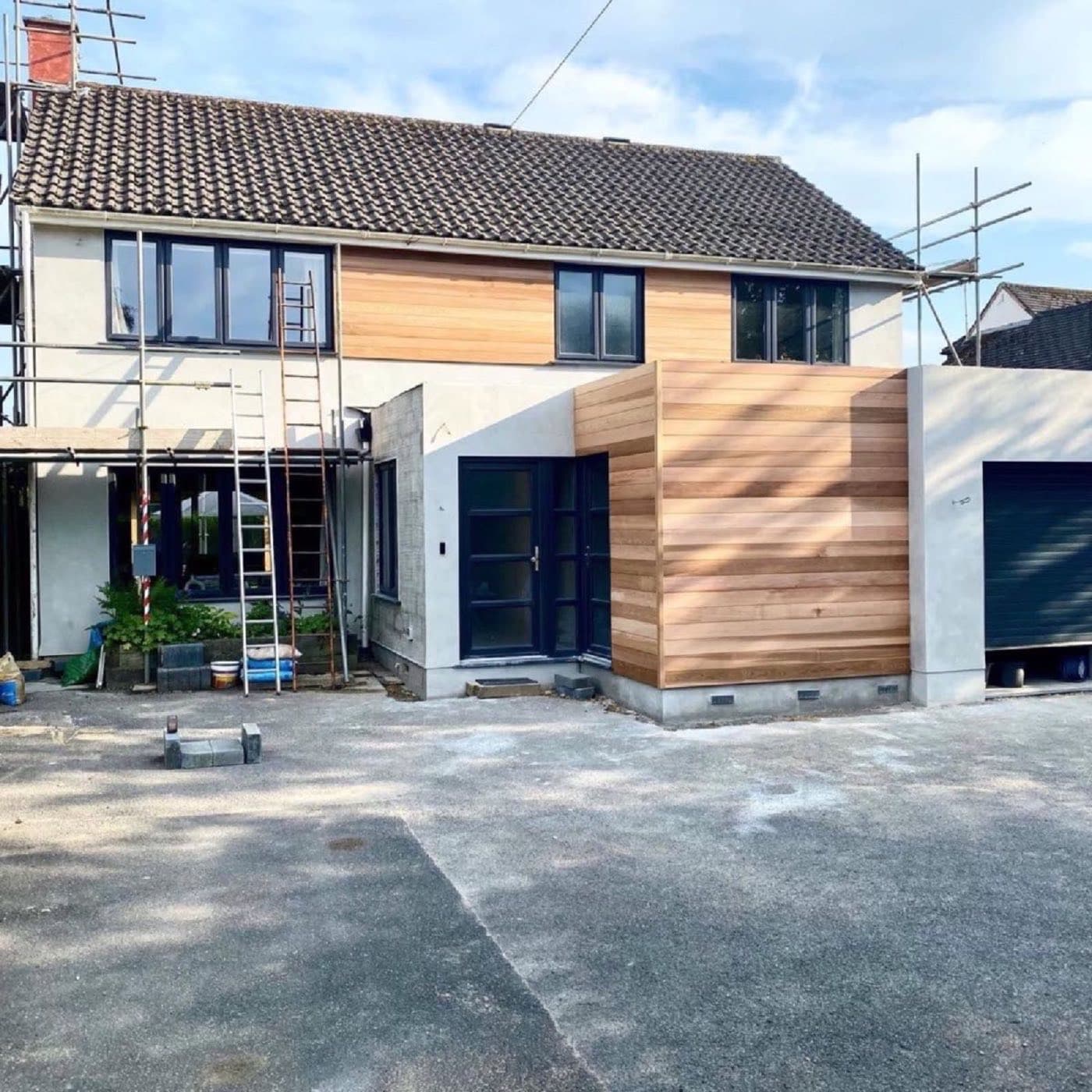 Cedar timber cladding fitted to a house extension with new windows, scaffolding still up
