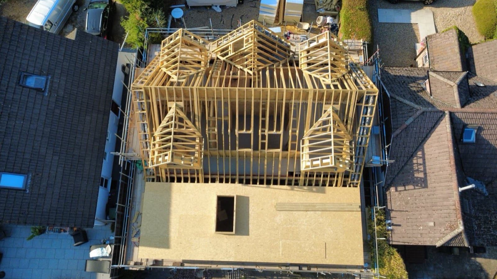 Aerial view of a timber-frame house extension roof and walls under construction