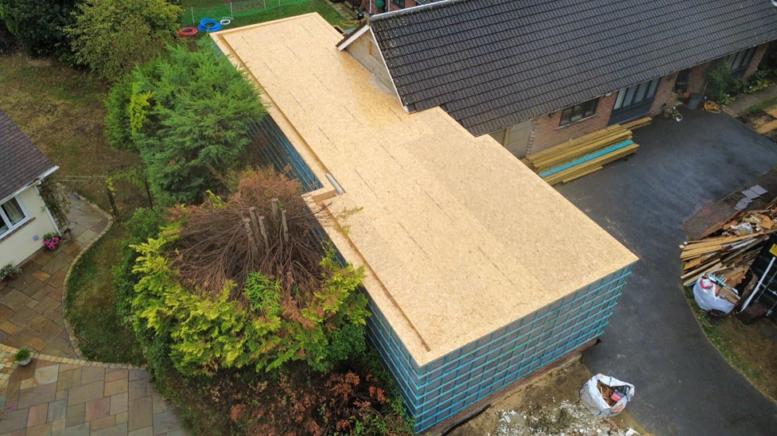 Aerial view of a timber-frame house extension roof deck under construction